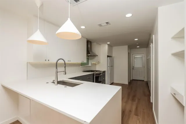 a kitchen with kitchen island a stove a sink and a refrigerator