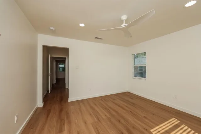 a view of a room with wooden floor and a ceiling fan