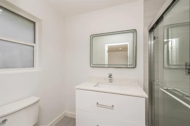 a bathroom with a toilet sink and mirror