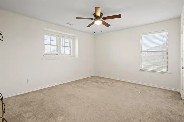 an empty room with a window and a fan