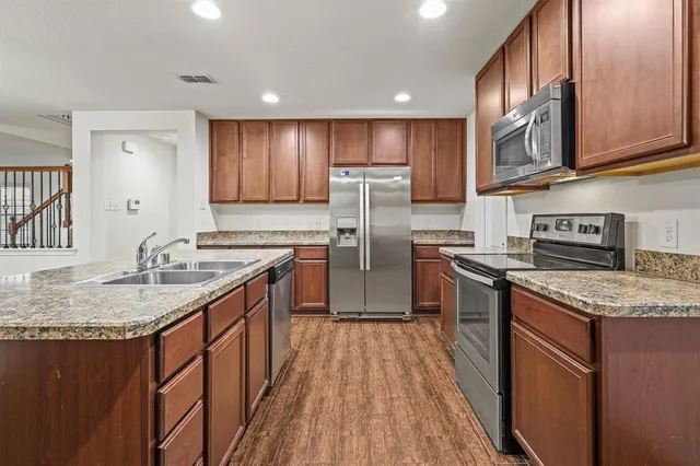 a kitchen with stainless steel appliances granite countertop a sink stove and refrigerator