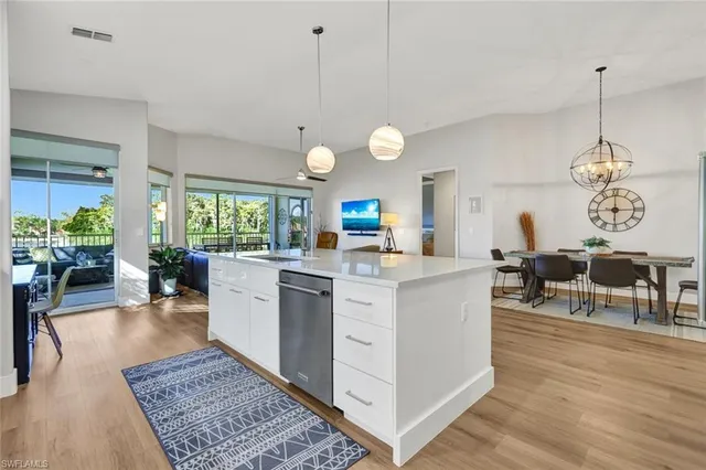 a large kitchen with kitchen island a counter space a sink a stove and living room view