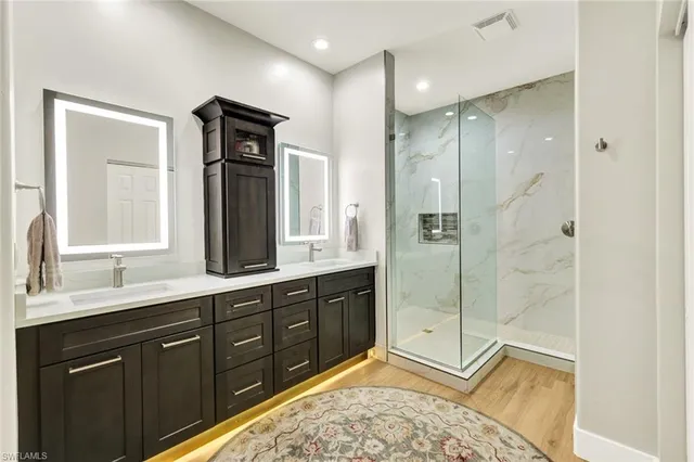 a spacious bathroom with a double vanity sink mirror and shower
