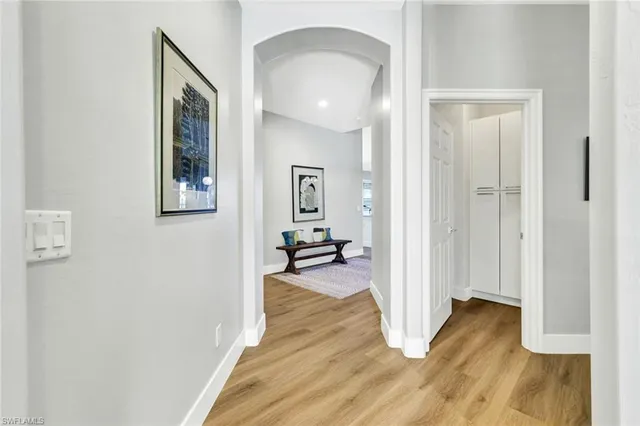 a view of a room that has a bed and wooden floor