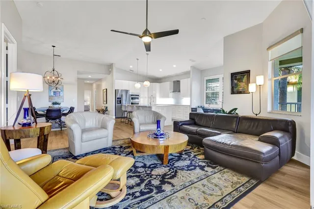 a living room with furniture a chandelier and a dining room