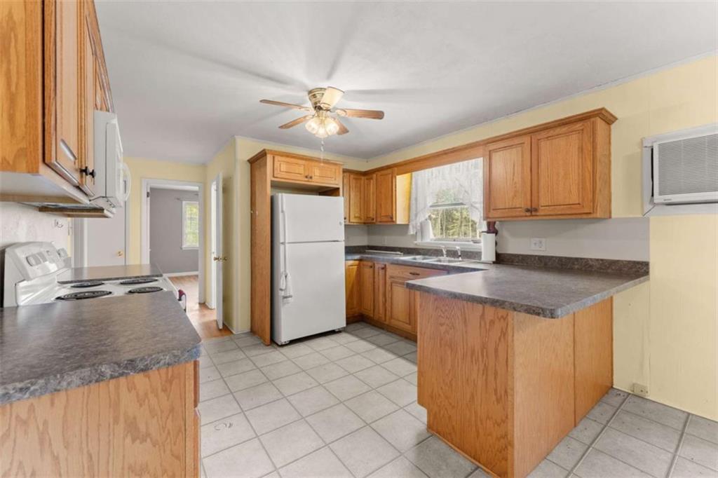 3772 Ledan Road Gainesville, GA 30506 - Photo 12 of 33 a kitchen with granite countertop a refrigerator a sink a stove and cabinets