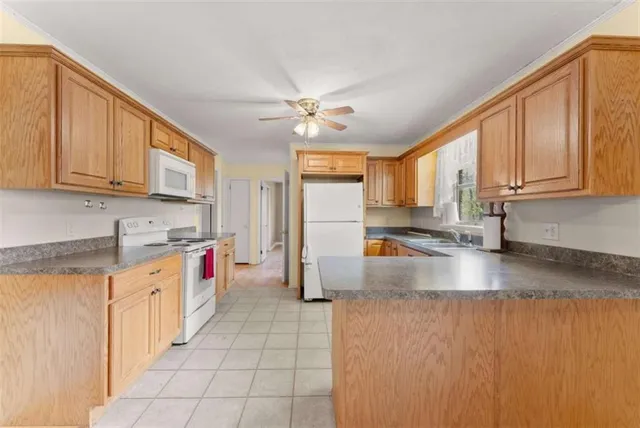 a large kitchen with stainless steel appliances granite countertop a stove a sink dishwasher and a refrigerator