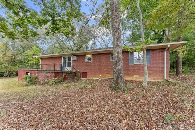 a view of a house with a yard and large tree