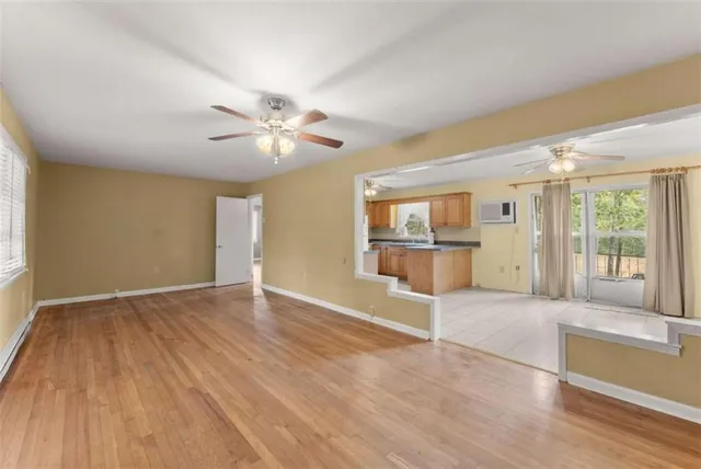 a view of a big room with wooden floor and a ceiling fan