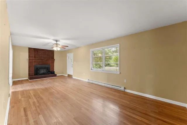 an empty room with windows and fireplace