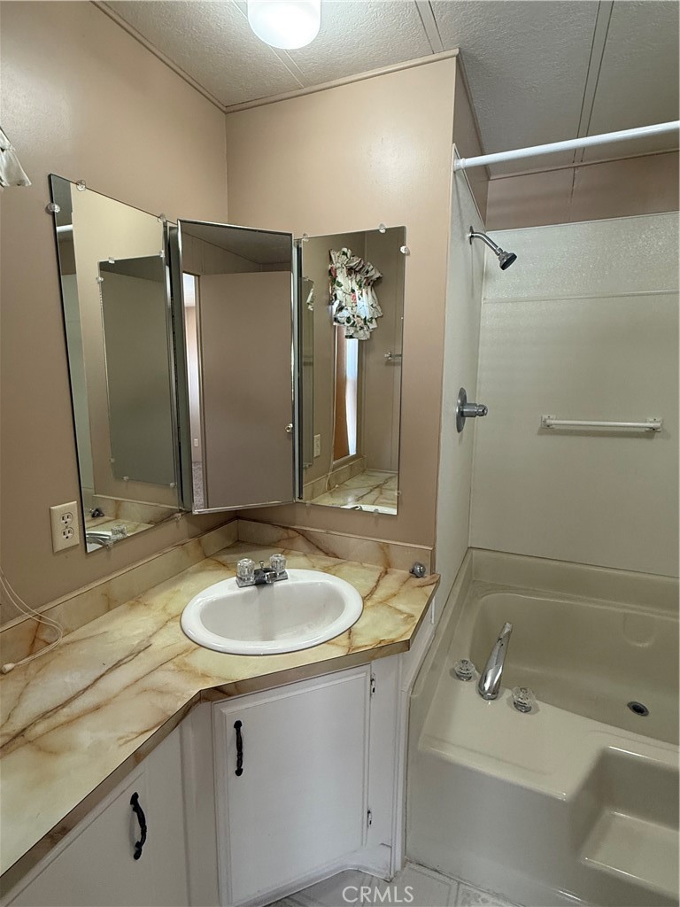 2240 Golden Oak Lane, Unit 108 Merced, CA 95341 - Photo 26 of 30 a bathroom with a sink double vanity granite tub shower and a mirror
