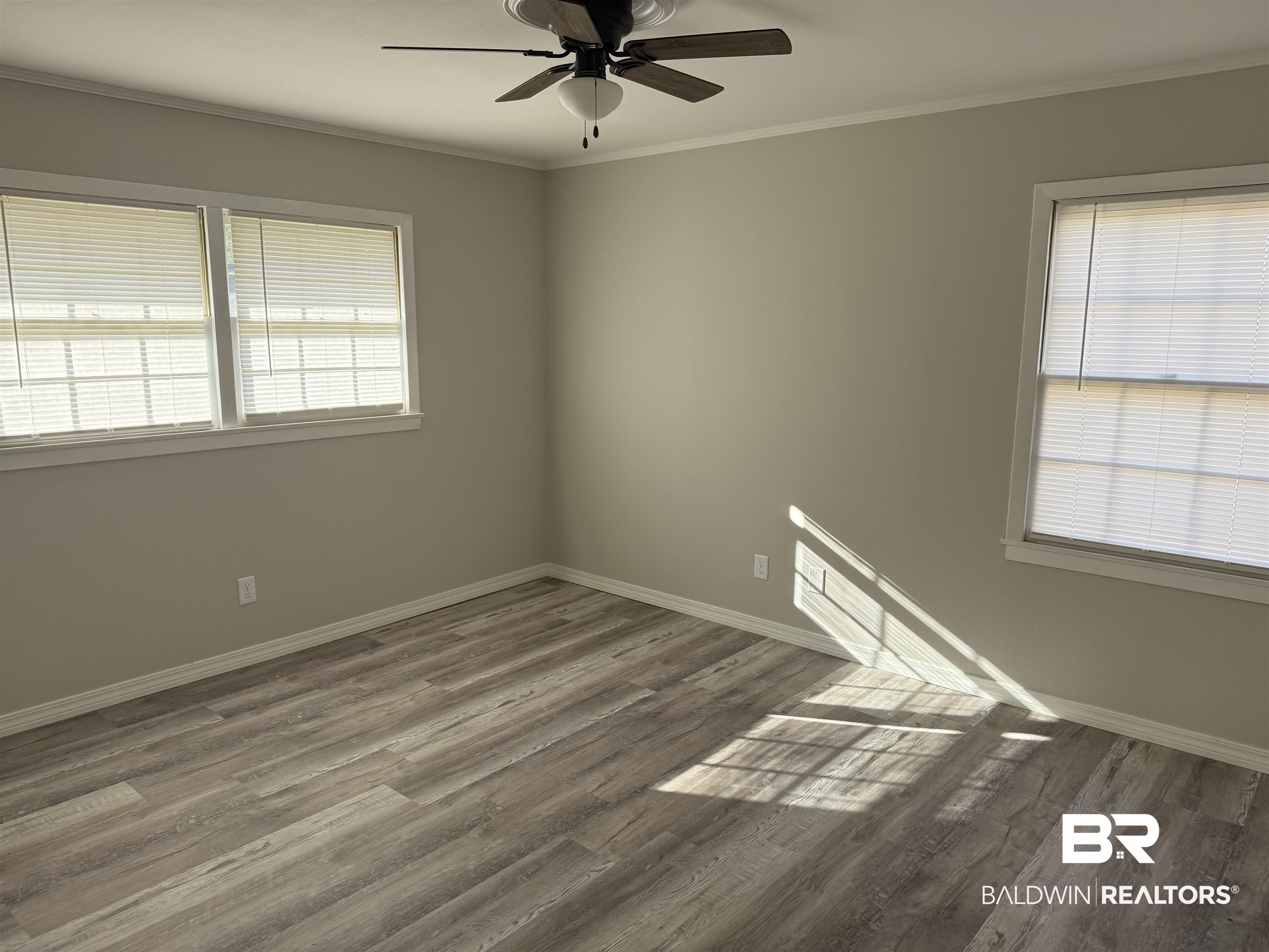 114 Spruce Avenue Brewton, AL 36426 - Photo 8 of 13 Empty room featuring crown molding, wood finished floors, plenty of natural light, and a ceiling fan