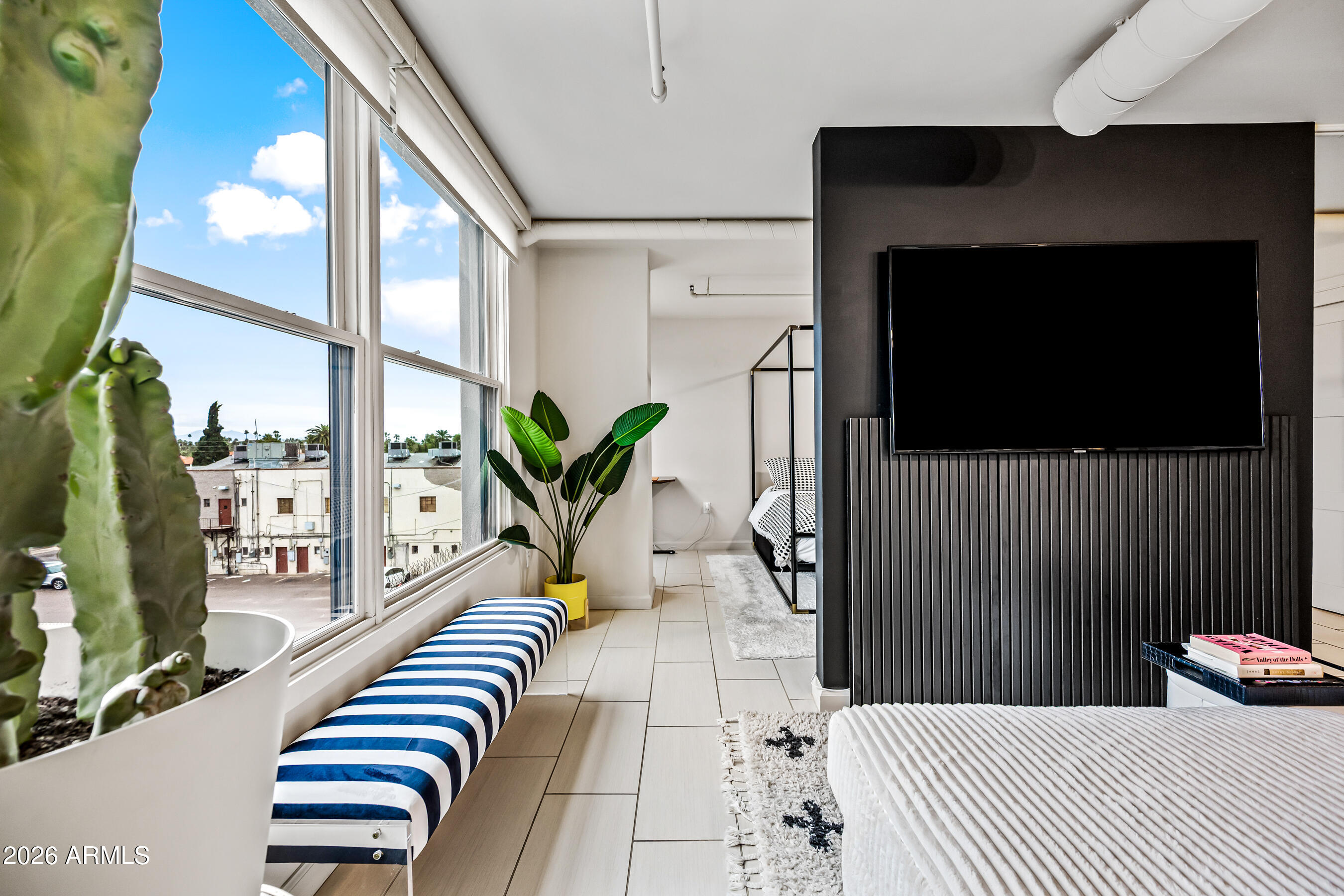 535 West Thomas Road, Unit 407 Phoenix, AZ 85013 - Photo 13 of 42 a bedroom with a bed and a flat screen tv