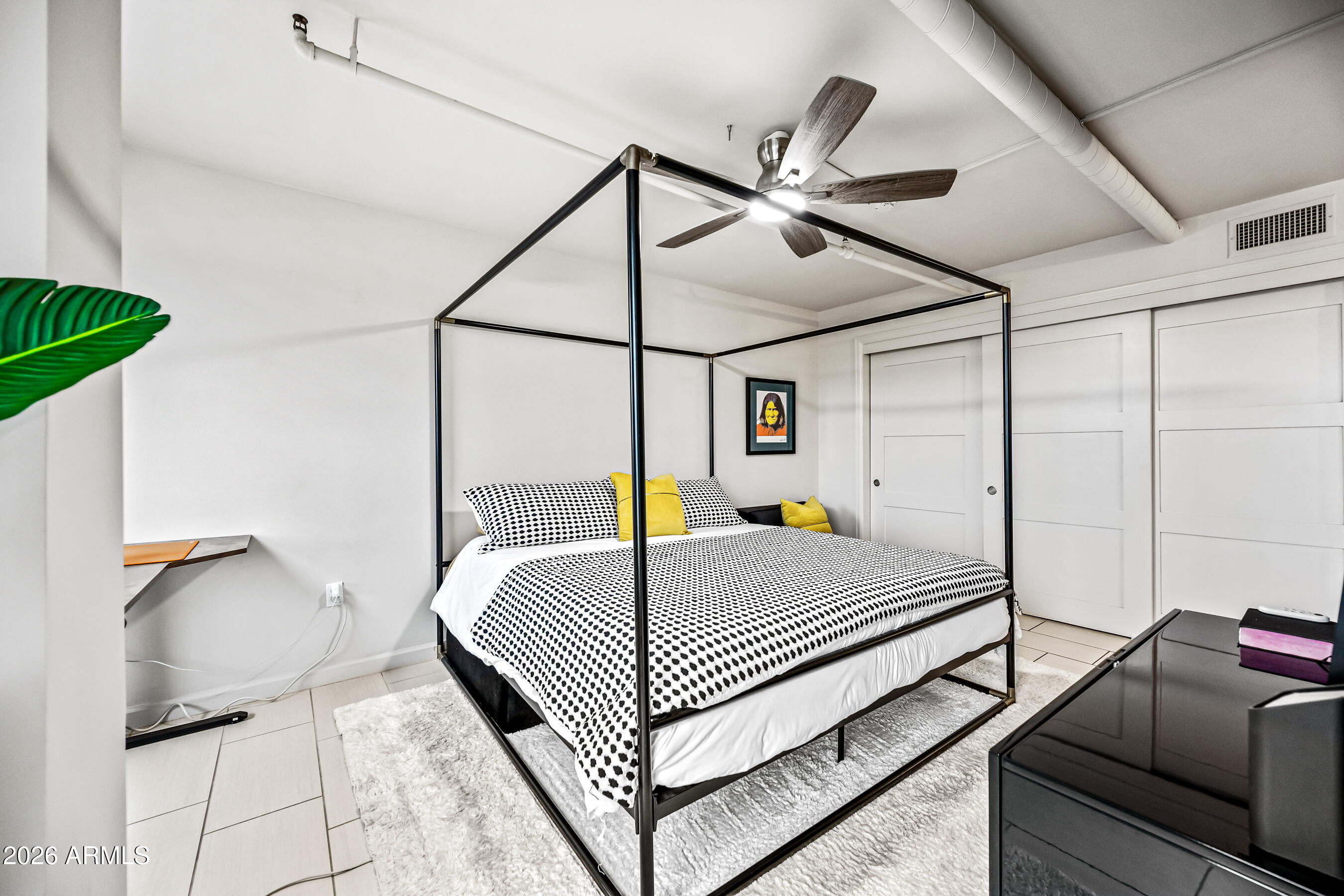 535 West Thomas Road, Unit 407 Phoenix, AZ 85013 - Photo 15 of 42 a bed room with a bed and a chandelier