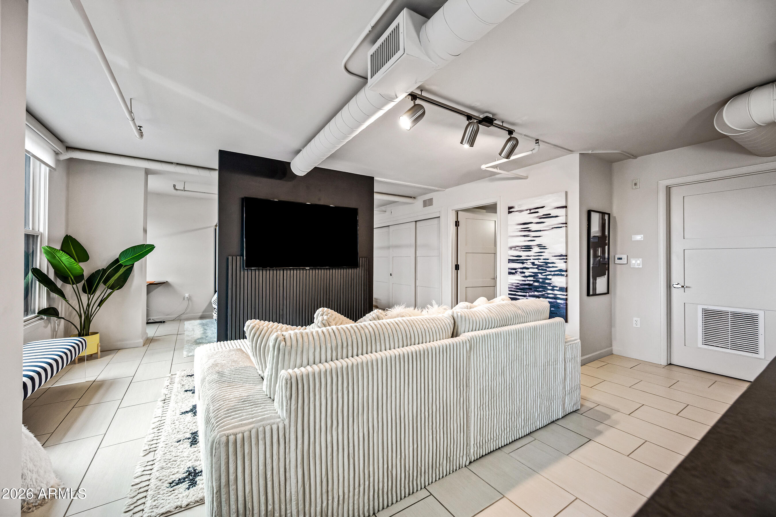 535 West Thomas Road, Unit 407 Phoenix, AZ 85013 - Photo 5 of 42 a living room with furniture and a flat screen tv