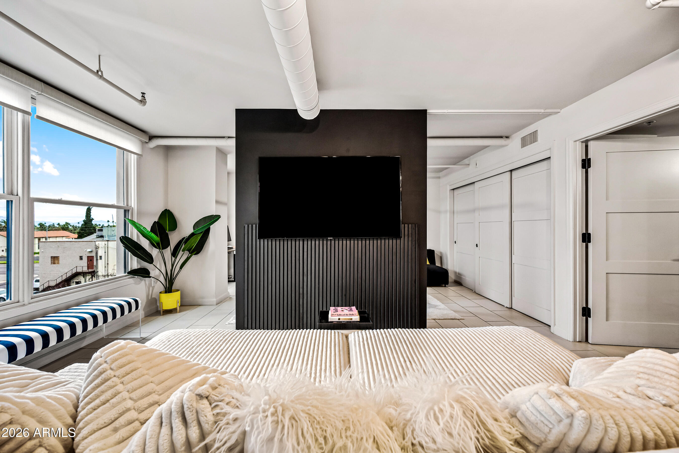 535 West Thomas Road, Unit 407 Phoenix, AZ 85013 - Photo 6 of 42 a bedroom with a bed and a flat screen tv