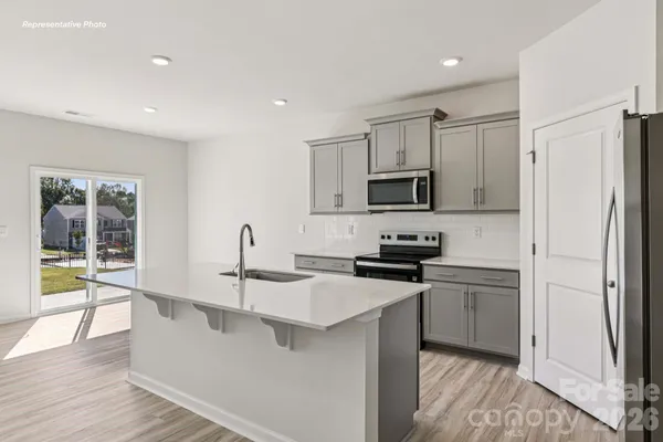 a kitchen with kitchen island a sink stainless steel appliances and counter space