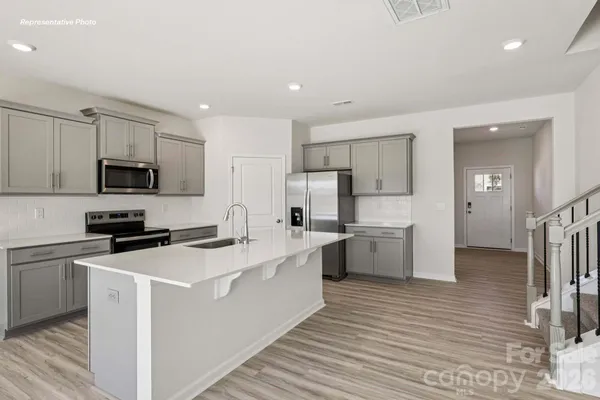 a kitchen with white cabinets stainless steel appliances and sink