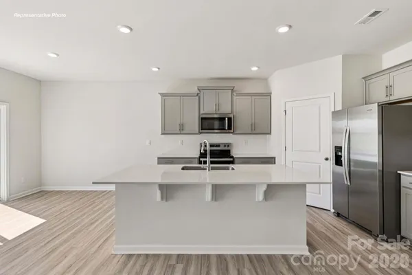 a kitchen with stainless steel appliances a refrigerator a sink a stove a microwave and cabinets