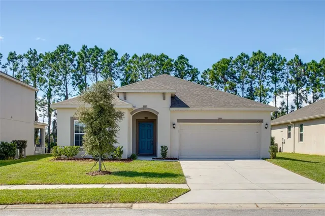a front view of a house with a yard and garage
