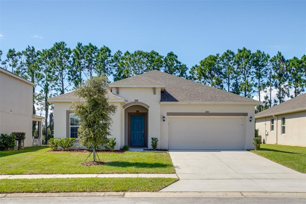 2520 Plumadore Drive Grand Island, FL 32735 - Photo 1 of 19 a front view of a house with a yard and garage