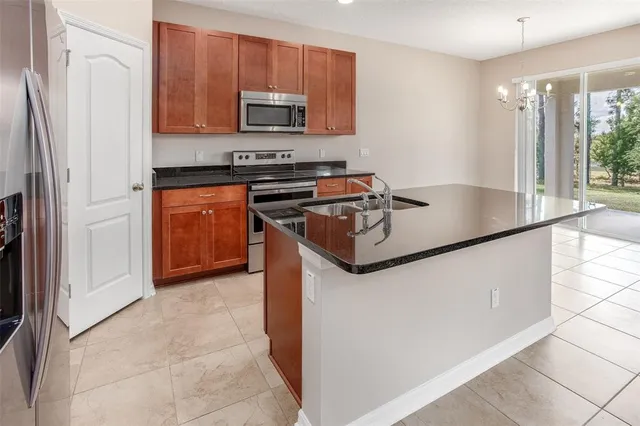 a kitchen with stainless steel appliances granite countertop a stove a sink and a refrigerator
