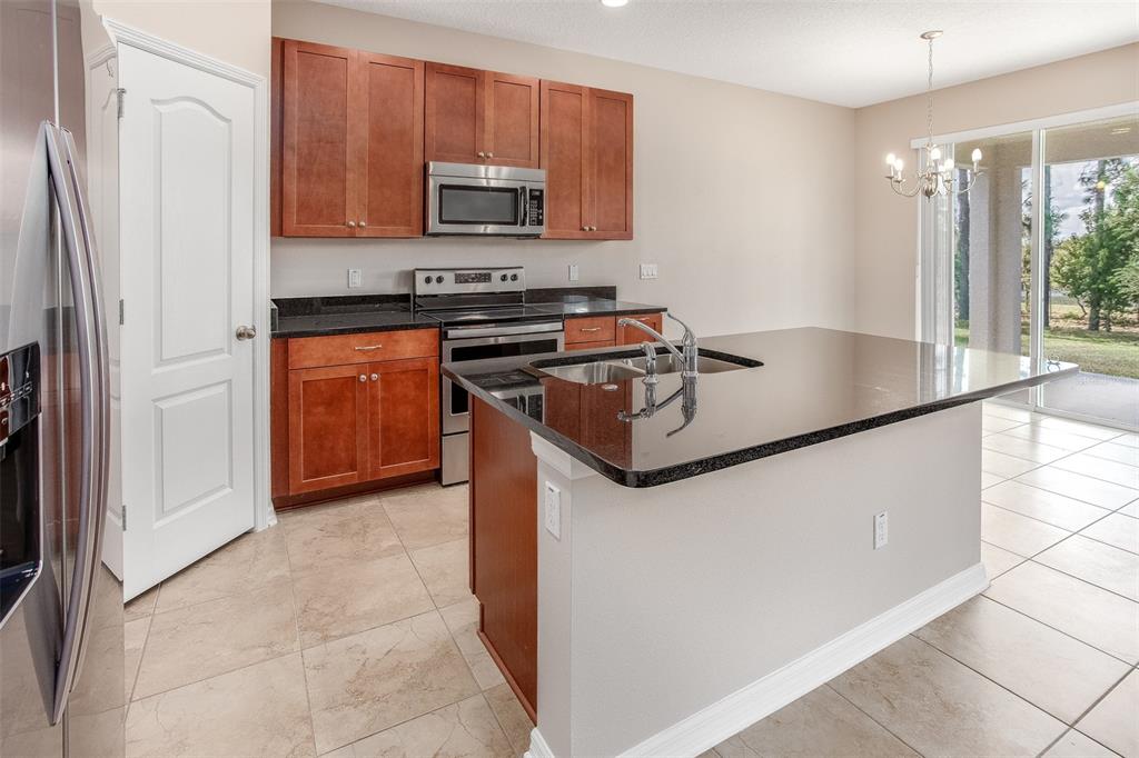 2520 Plumadore Drive Grand Island, FL 32735 - Photo 3 of 19 a kitchen with stainless steel appliances granite countertop a stove a sink and a refrigerator