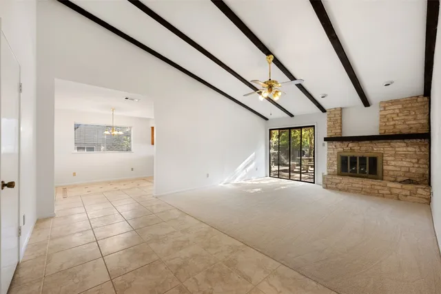 a view of an empty room with a fireplace and a window