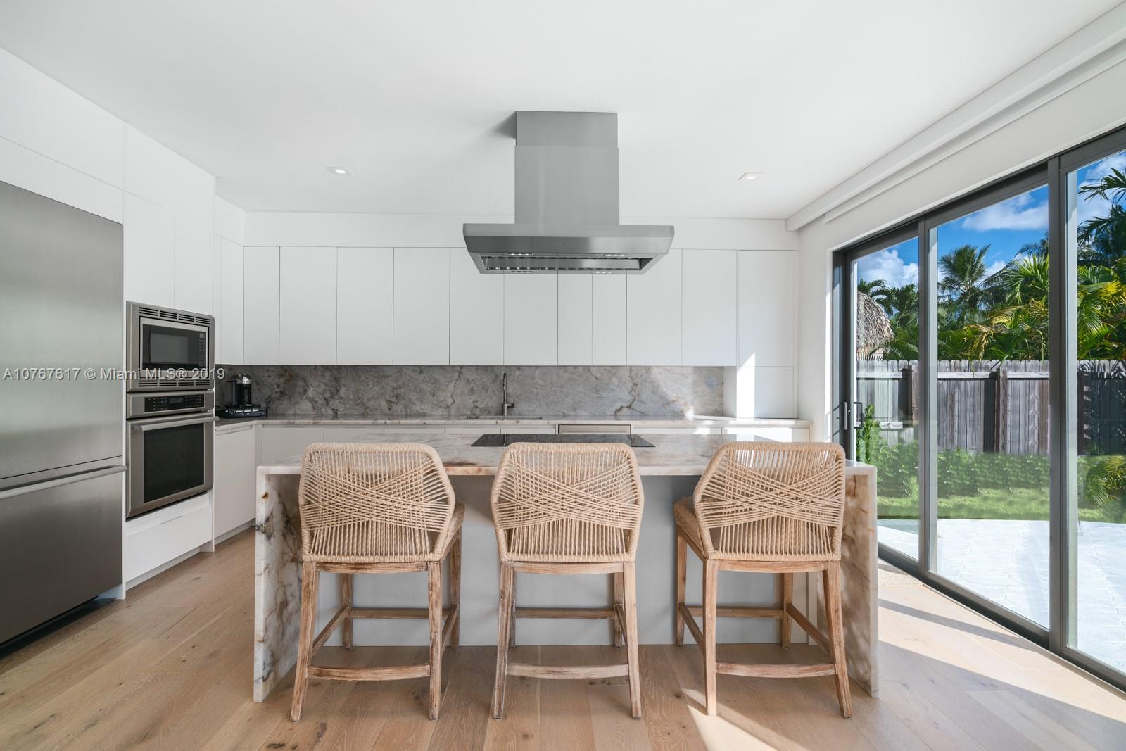 1320 Cleveland Road Miami Beach, FL 33141 - Photo 5 of 16 a kitchen with a table chairs stove and refrigerator