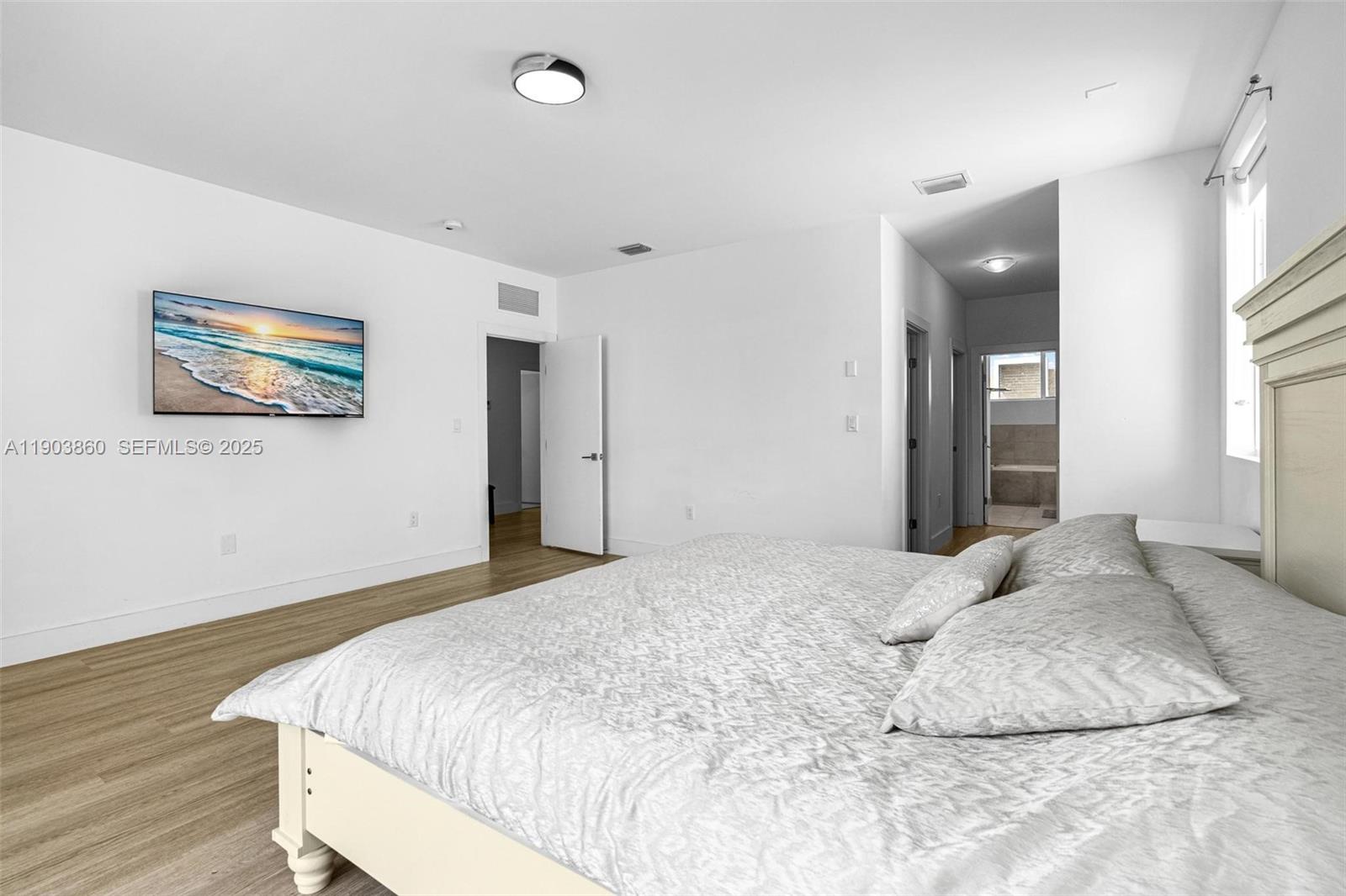 10330 Northwest 68th Street Doral, FL 33178 - Photo 27 of 60 a bedroom with a bed and a painting on the wall