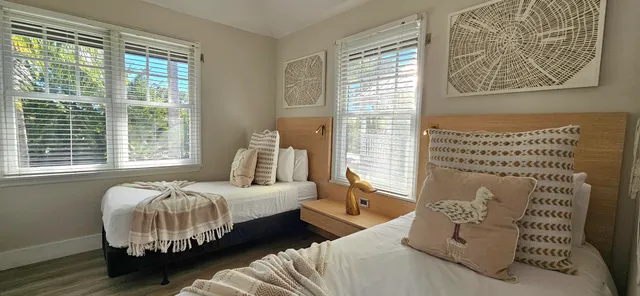 a bedroom with a bed and two windows