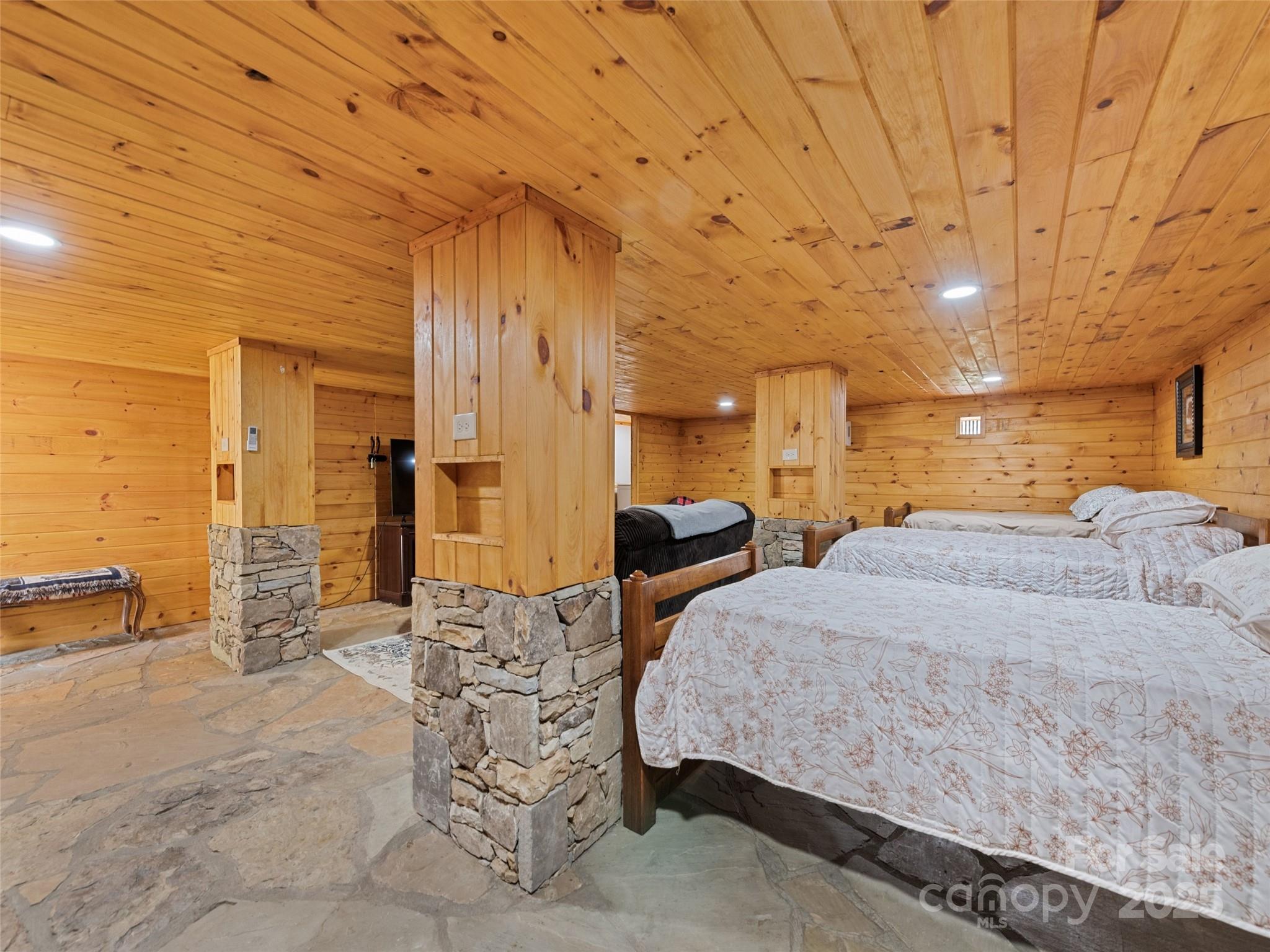 229 Yellow Bird Br Road Sylva, NC 28779 - Photo 31 of 34 a spacious bedroom with a bed a table and flowerpot