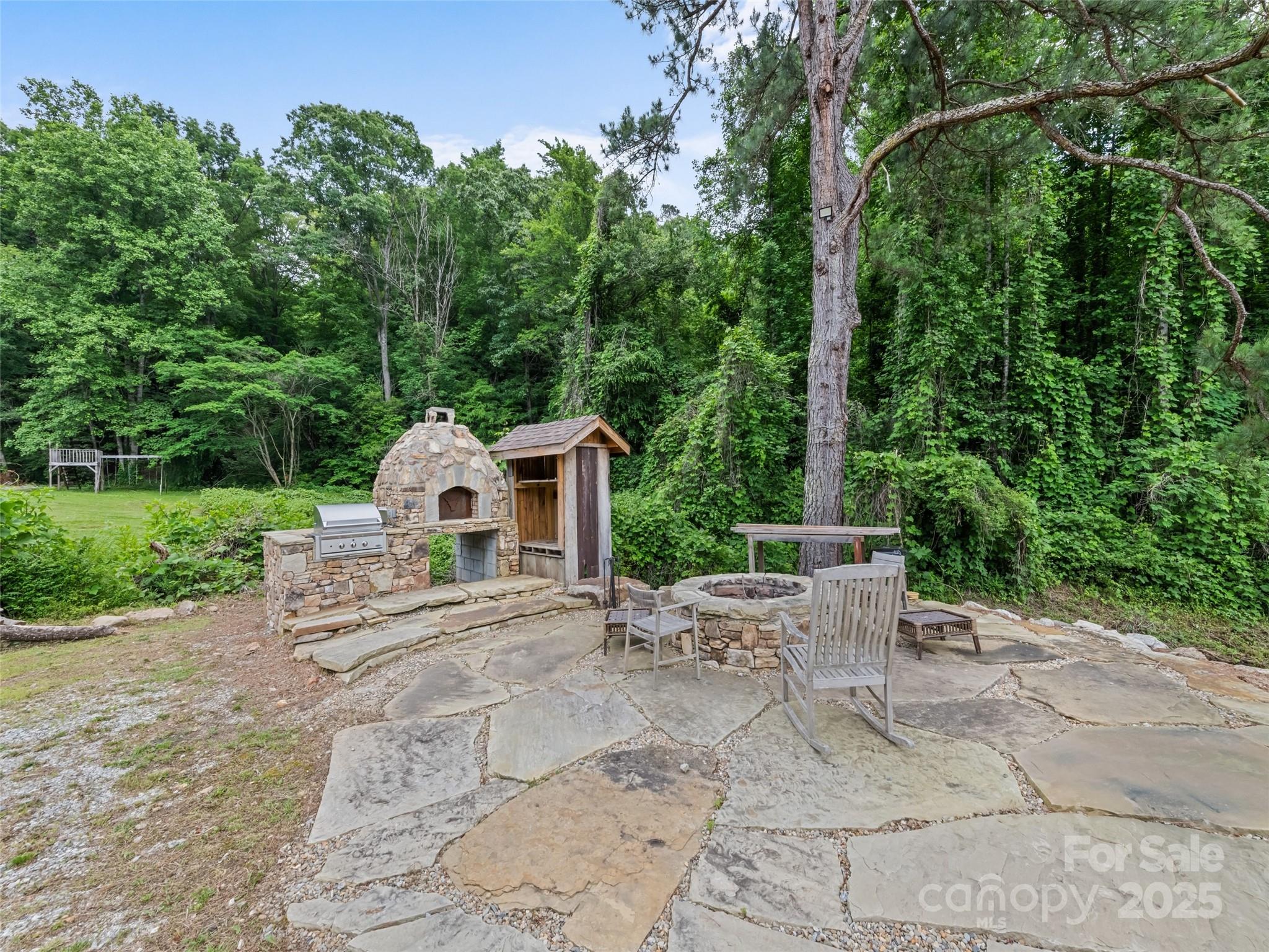 229 Yellow Bird Br Road Sylva, NC 28779 - Photo 7 of 34 a view of a patio with a table and chairs under an umbrella