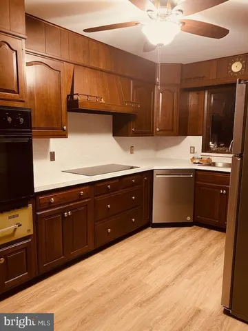 a kitchen with stainless steel appliances a sink a refrigerator and cabinets