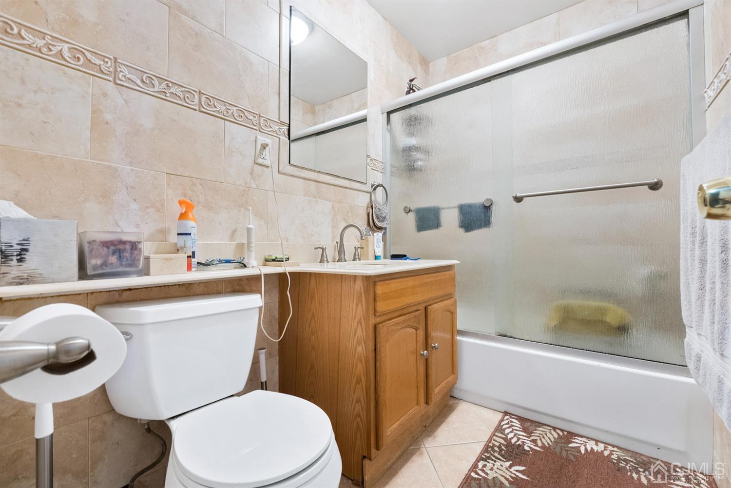 390 College Drive Edison, NJ 08817 - Photo 13 of 17 a bathroom with a sink a mirror a toilet and shower