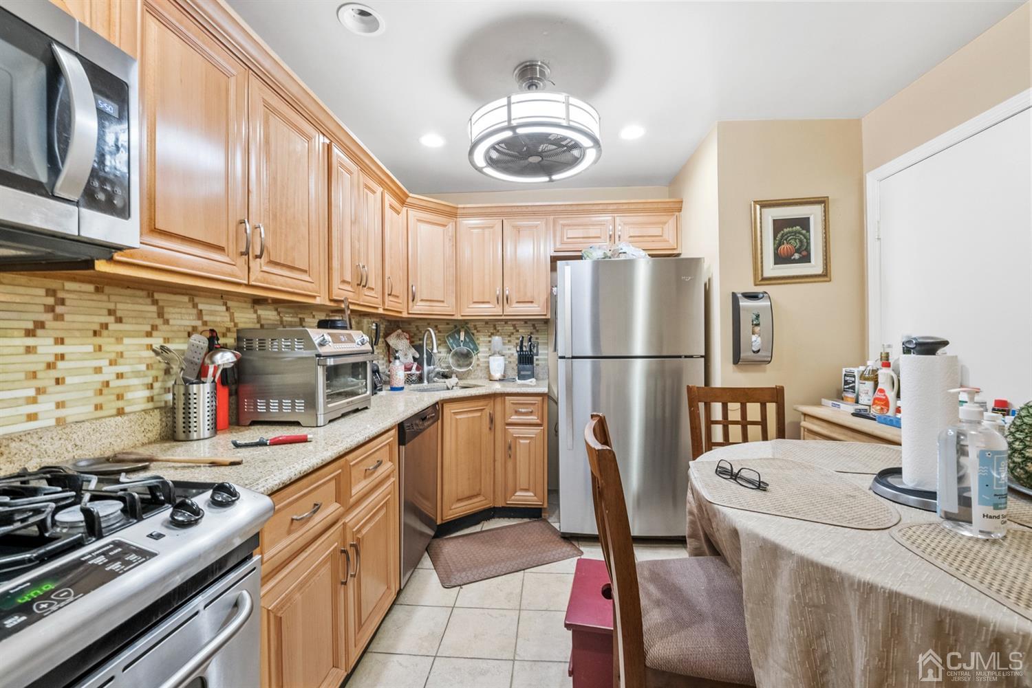 390 College Drive Edison, NJ 08817 - Photo 7 of 17 a kitchen with stainless steel appliances granite countertop a refrigerator and a stove top oven