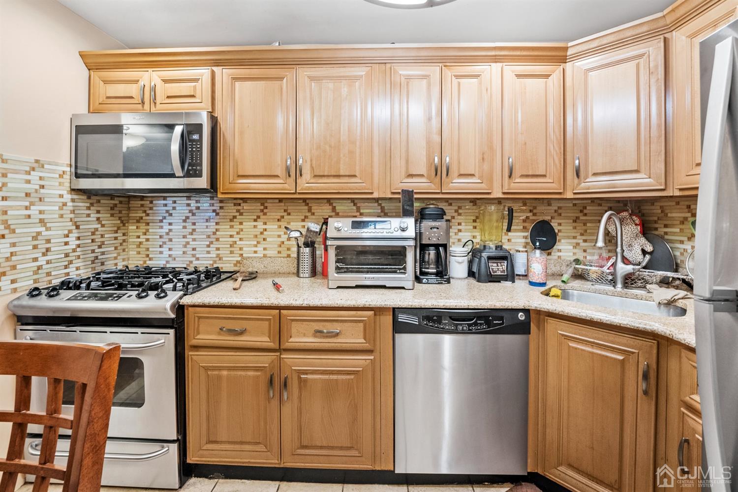 390 College Drive Edison, NJ 08817 - Photo 8 of 17 a kitchen with stainless steel appliances granite countertop a stove a sink and a microwave