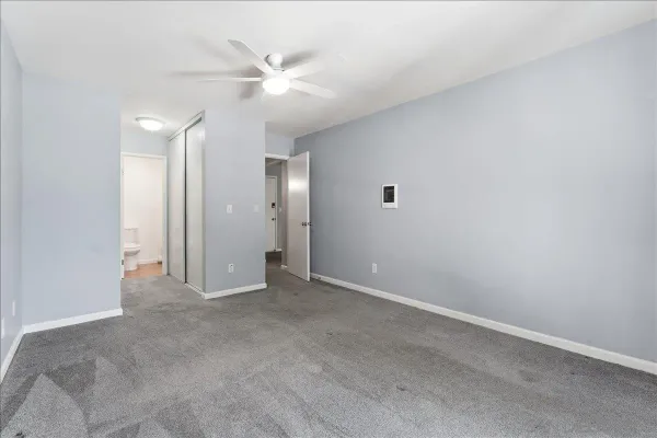 an empty room with a ceiling fan and bathroom