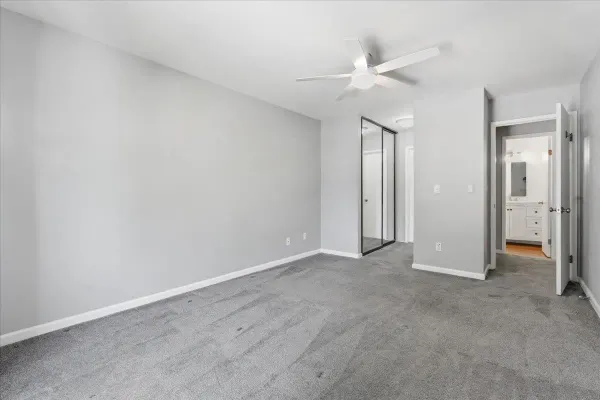 an empty room with a ceiling fan and bathroom