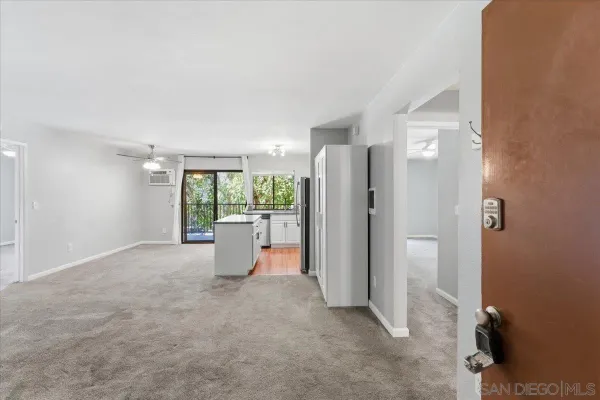 a view of a room with furniture and a refrigerator