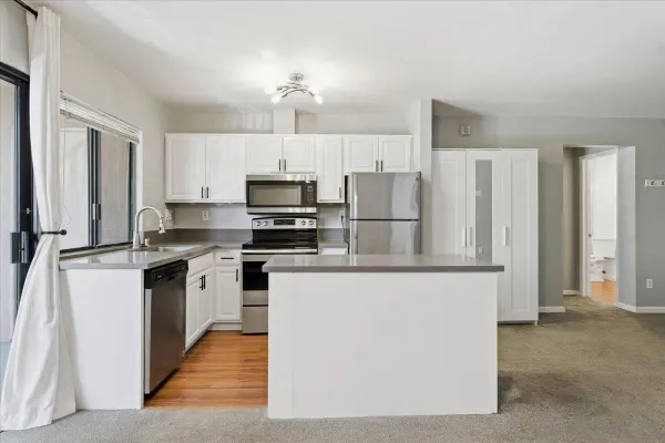 a kitchen with stainless steel appliances a refrigerator sink and microwave