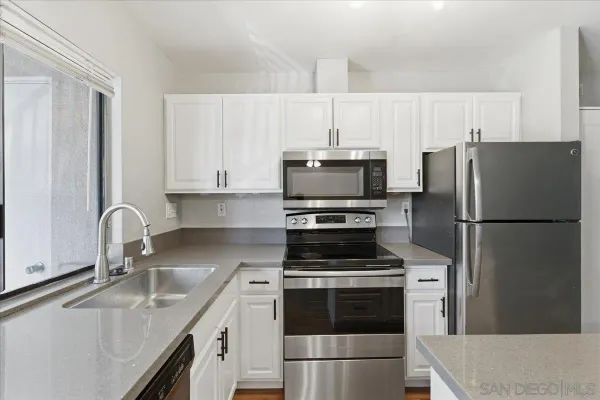 a kitchen with kitchen island a sink stainless steel appliances and cabinets