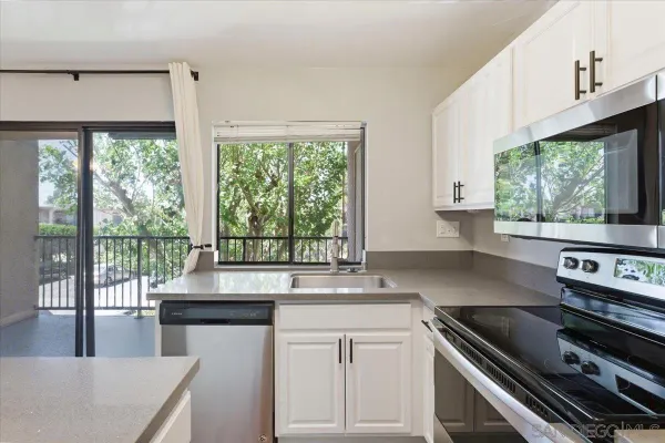 a kitchen with kitchen island a large window a sink and appliances