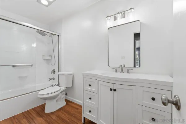 a bathroom with a double vanity sink toilet mirror and shower