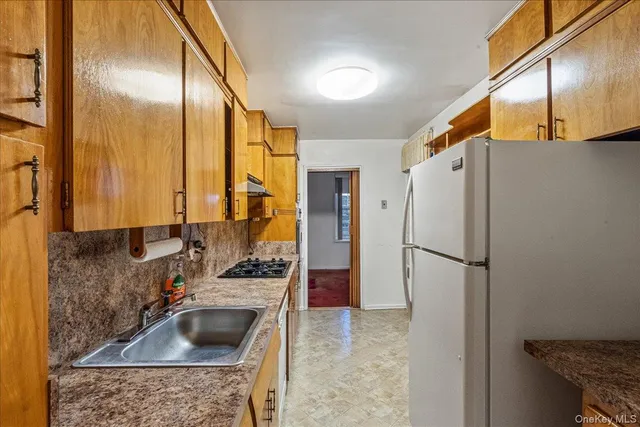 a kitchen with stainless steel appliances granite countertop a refrigerator a sink and a stove