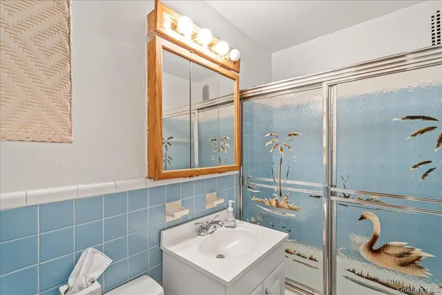 a bathroom with a sink mirror and toilet