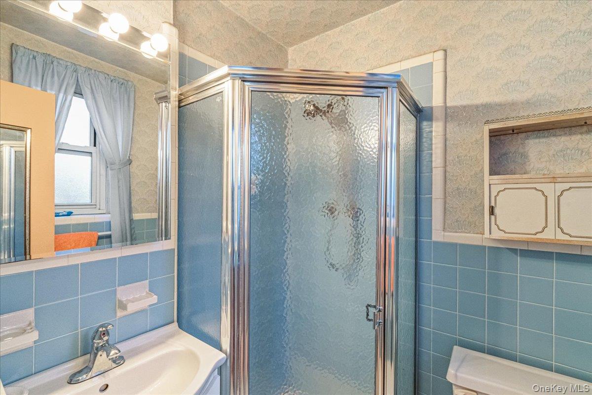 209-25 18th Avenue, Unit 6D Queens, NY 11360 - Photo 17 of 26 a bathroom with a shower a toilet and a sink