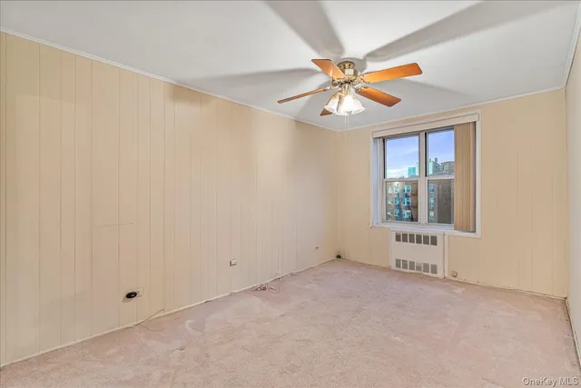 an empty room with chandelier fan