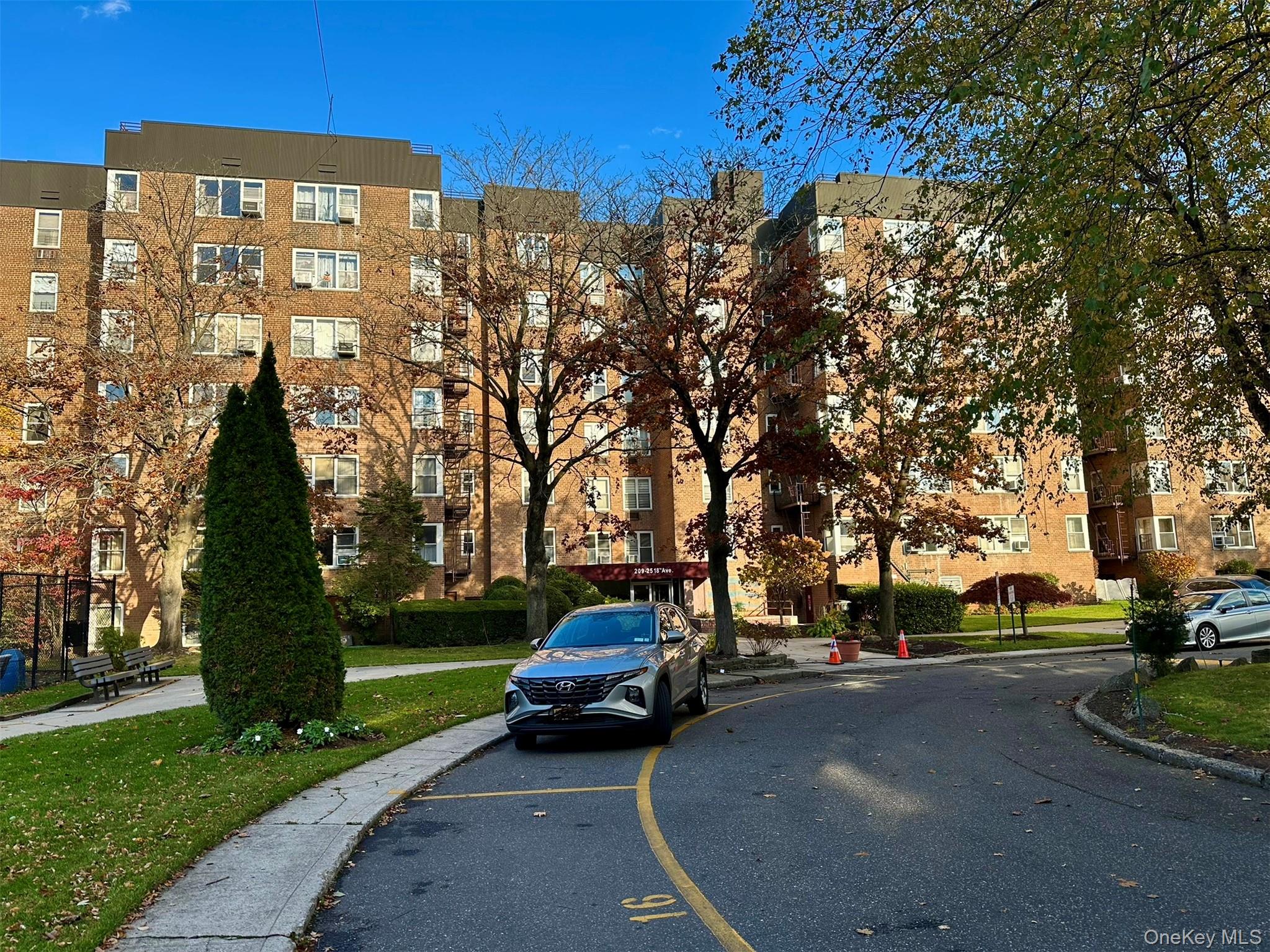 209-25 18th Avenue, Unit 6D Queens, NY 11360 - Photo 3 of 26 a city view with tall buildings and cars parked on road