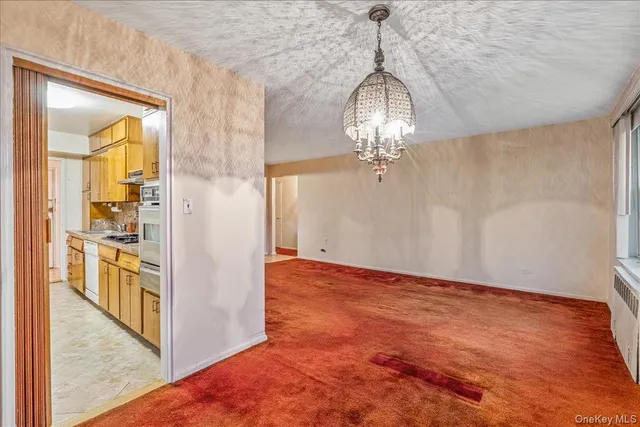 a view of a hallway with wooden floor and a chandelier